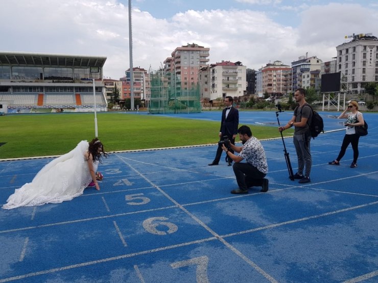 Düğün fotoğraflarını aşklarının başladığı atletizm sahasında koşarak çektirdiler